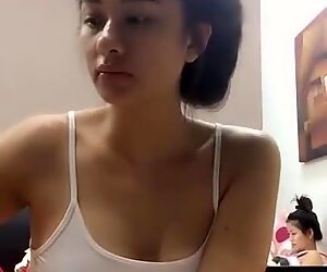 gorgeous young Thai girl in nightie in front of her webcam